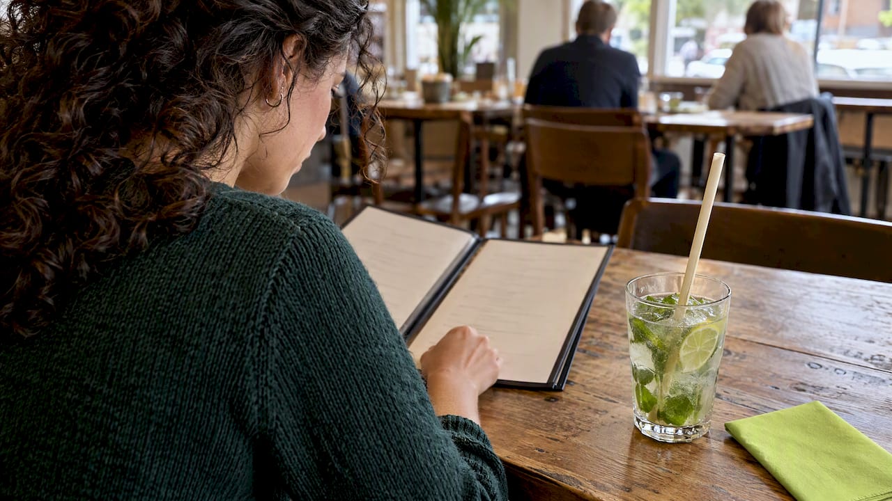 Gast maakt een duurzame keuze aan een cafétafel
