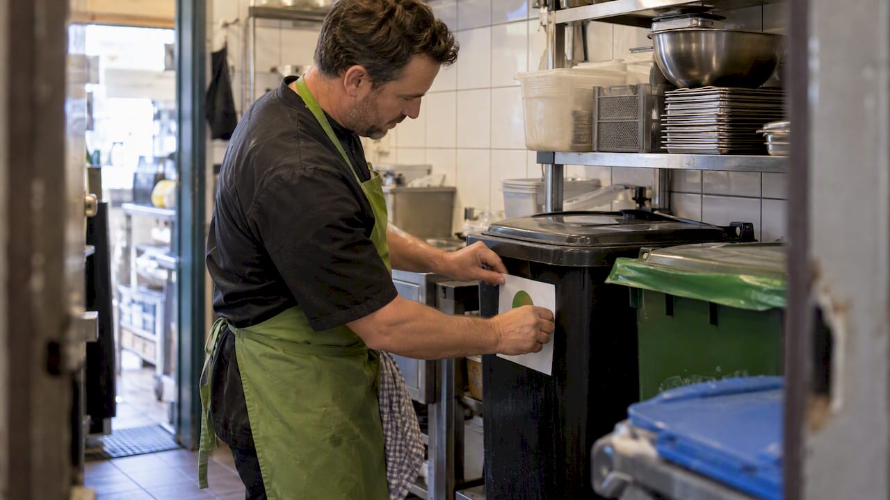 Horecaondernemer plakt etiket op afvalbak in café